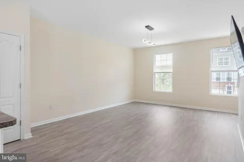 a kitchen with stainless steel appliances kitchen island wooden floors and white walls