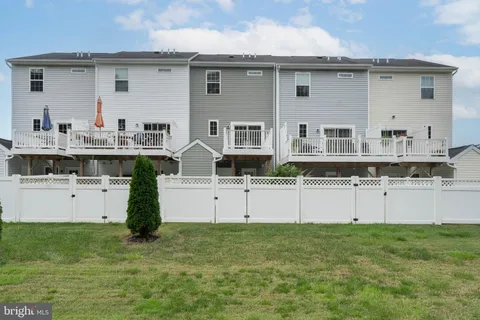 an aerial view of residential houses with outdoor space and trees