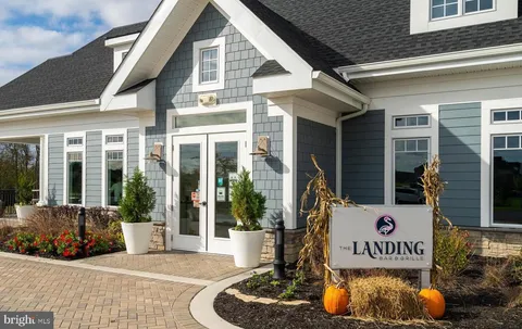 a living room with furniture a fireplace and large windows