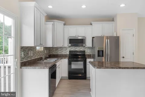 a kitchen with a refrigerator stove and microwave