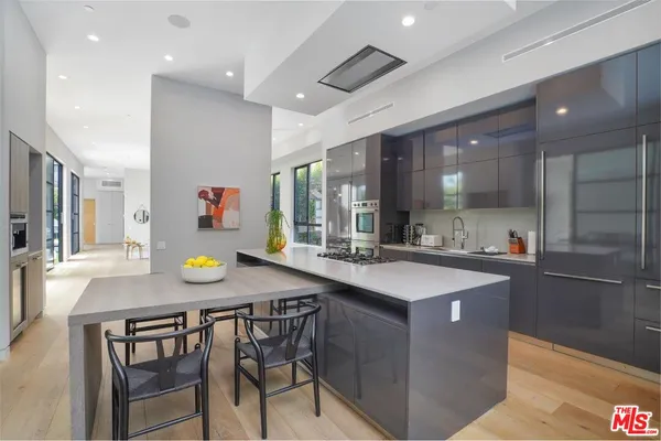 a kitchen with kitchen island granite countertop a sink and stainless steel appliances