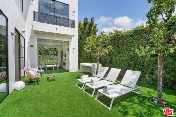 a view of a chair and table in backyard of the house
