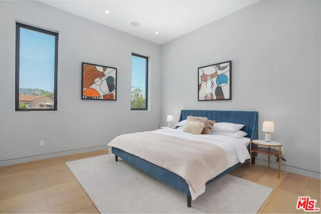 a bedroom with a bed and painting on the wall