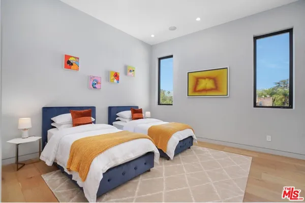 a bedroom with two beds and a painting on the wall