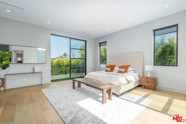 a bedroom with furniture and a large window
