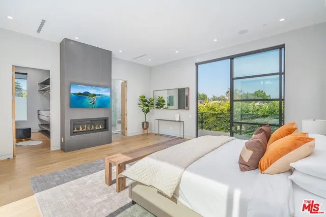 a bedroom with a bed and a large window