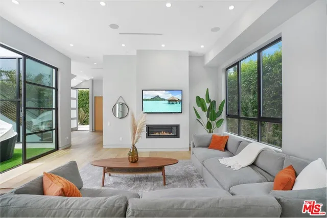 a living room with fireplace furniture and a large window