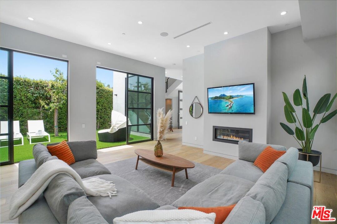 346 North Kings Road Los Angeles, CA 90048 - Photo 10 of 33 a living room with furniture floor to ceiling window and a flat screen tv