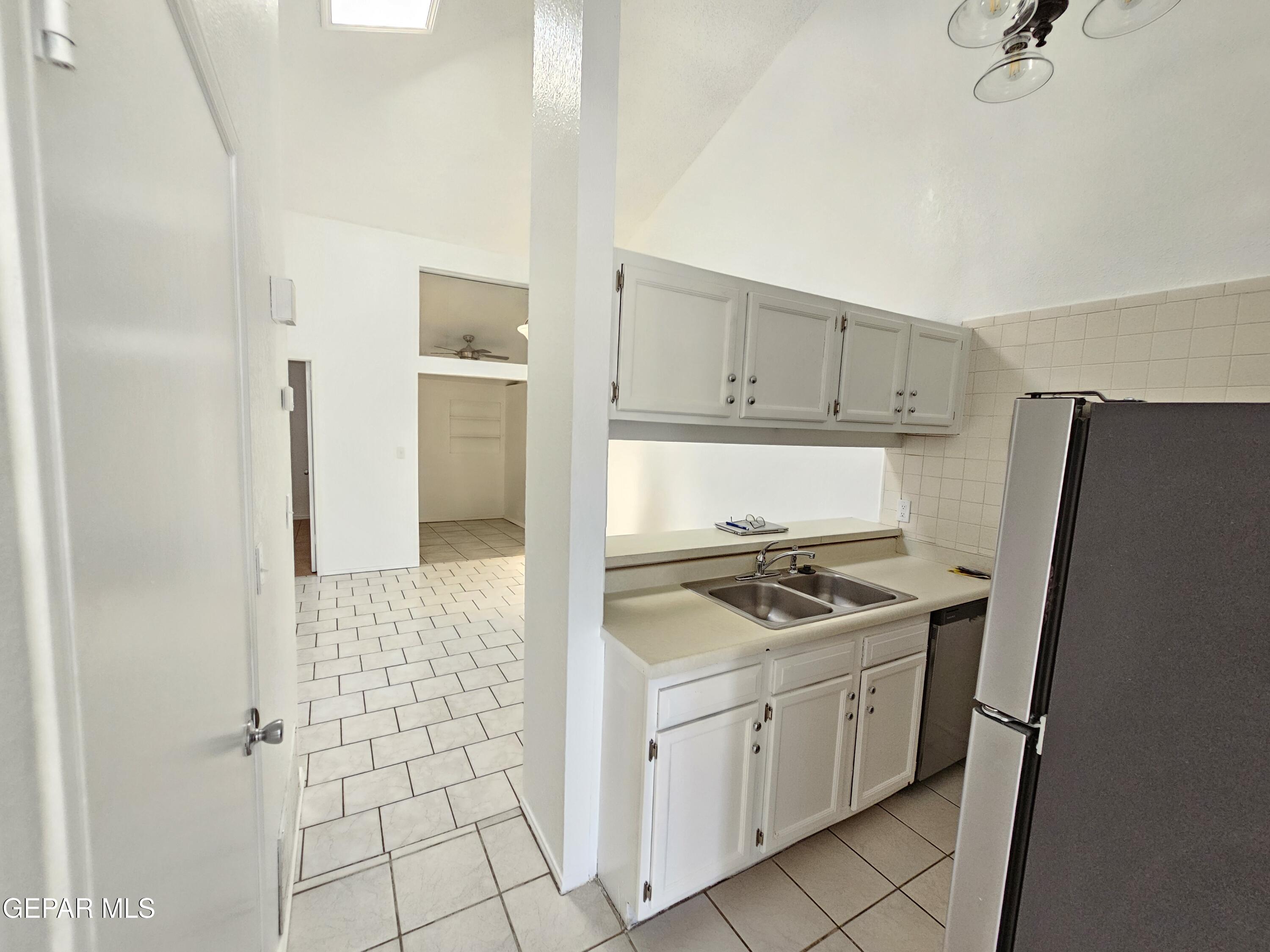 833 Destello Road El Paso, TX 79907 - Photo 18 of 55 a kitchen with a stove a refrigerator and a white cabinets