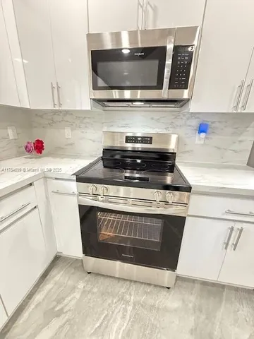 a stove top oven sitting inside of a kitchen