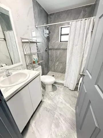 a bathroom with a sink toilet and shower