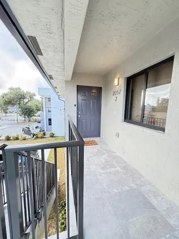 a view of a hallway with wooden floor and stairs