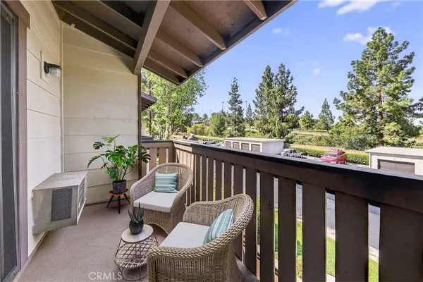 a balcony with wooden floor potted plants and outdoor seating