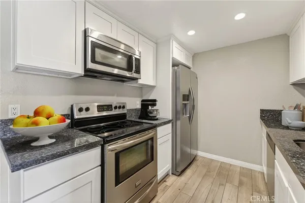 a kitchen with stainless steel appliances granite countertop a stove a refrigerator and a microwave