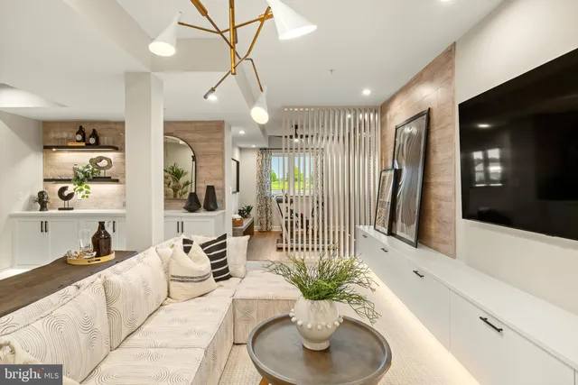 a living room with furniture a chandelier and a flat screen tv