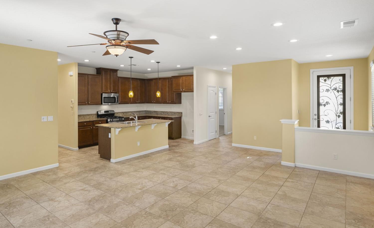 3451 Rainhill Loop Roseville, CA 95747 - Photo 7 of 40 a large kitchen with stainless steel appliances granite countertop a stove and a refrigerator