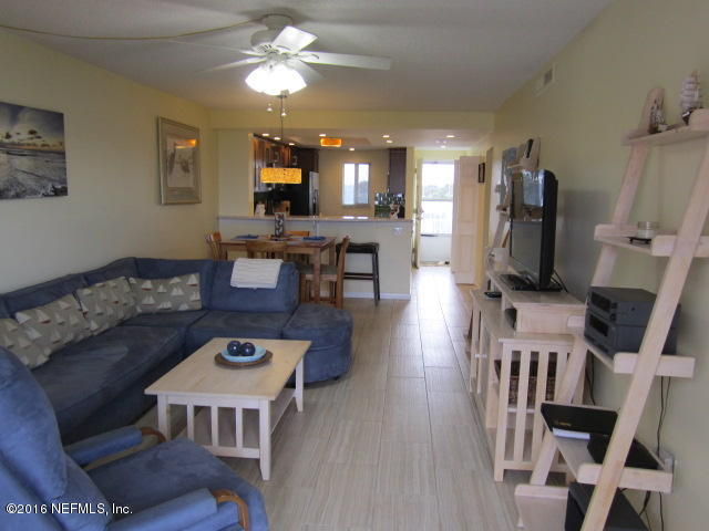 4 Ocean Trace Road, Unit 422 St. Augustine, FL 32080 - Photo 13 of 33 a living room with furniture a flat screen tv and a dining table