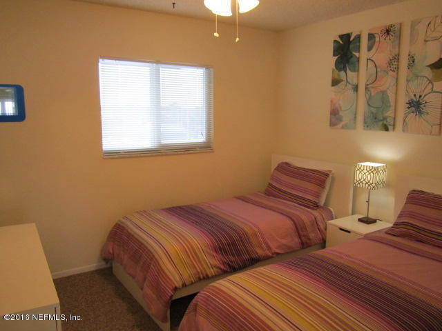 4 Ocean Trace Road, Unit 422 St. Augustine, FL 32080 - Photo 15 of 33 a bedroom with two beds and painting on the wall