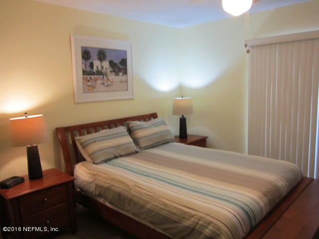 4 Ocean Trace Road, Unit 422 St. Augustine, FL 32080 - Photo 20 of 33 a bedroom with a bed and a painting on the wall