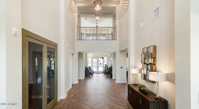 a view of hallway with furniture and chandelier