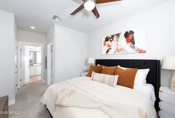 a bedroom with a bed and painting on the wall