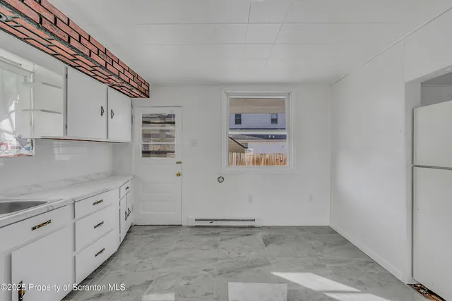 a view of kitchen with stainless steel appliances a sink and cabinets
