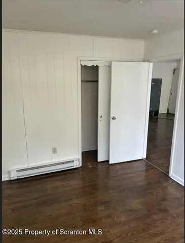 an empty room with wooden floor and closet