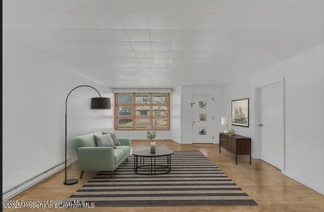 a view of an empty room with window and hardwood floor