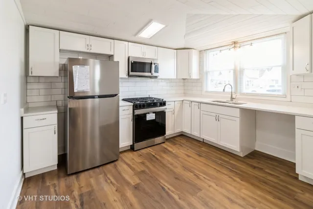 a kitchen with a refrigerator sink and cabinets