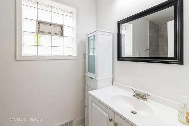 a bathroom with a sink mirror and vanity