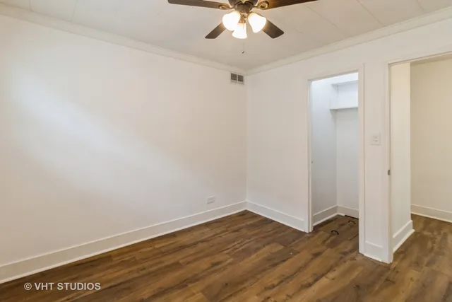 a view of a room with wooden floor and ceiling fan