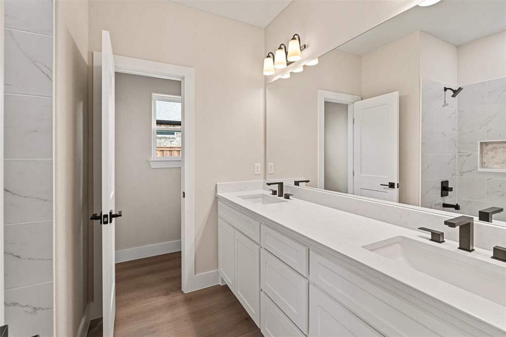506 Limestone Circle Mabank, TX 75147 - Photo 20 of 33 a bathroom with a double vanity sink a mirror and a shower