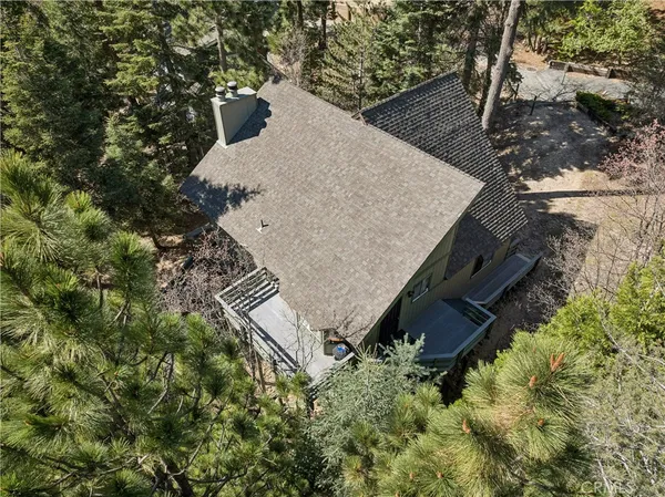 an aerial view of a house with a yard and large trees