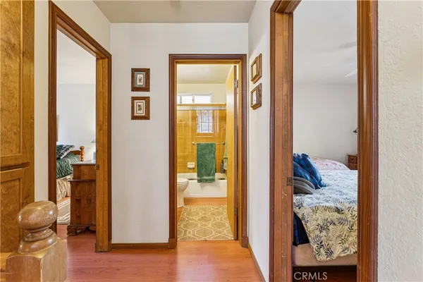 a view of a hallway with wooden floor and a livingroom