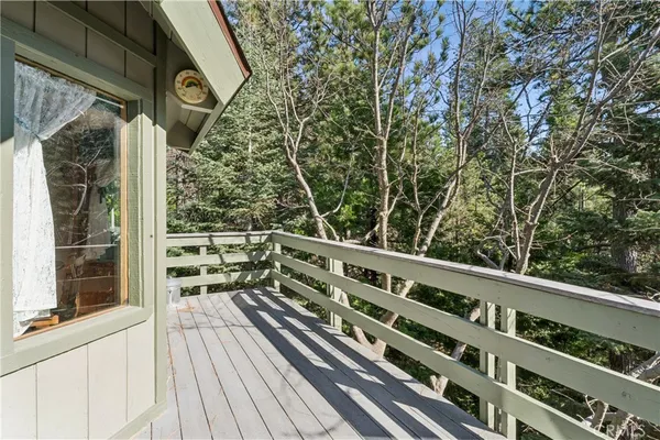 a view of balcony with wooden floor and fence