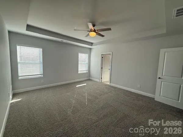 an empty room with windows and fan