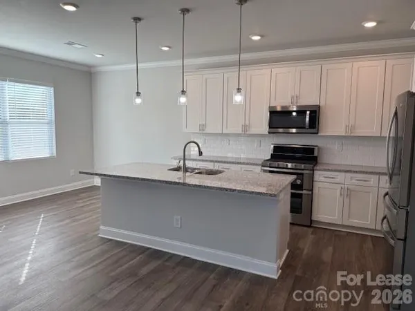 a kitchen with kitchen island a sink stainless steel appliances and cabinets