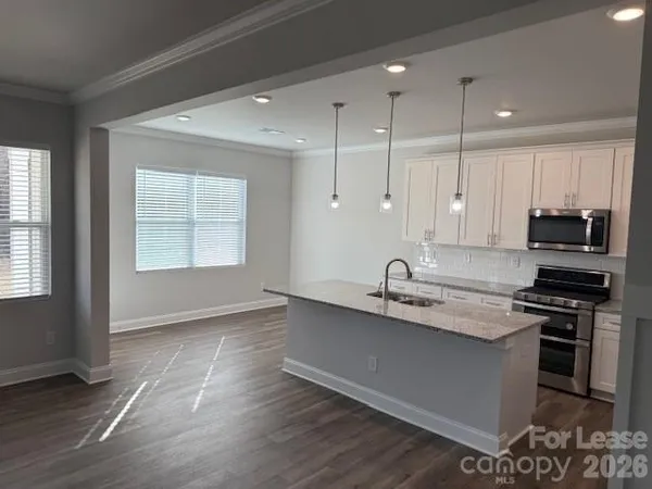 a kitchen with granite countertop a sink stove and cabinets