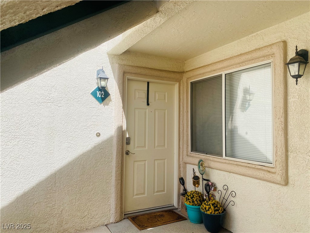 717 Wheat Ridge Lane, Unit 102 Las Vegas, NV 89145 - Photo 6 of 8 View of exterior entry featuring stucco siding
