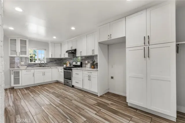 a kitchen with white cabinets and black appliances