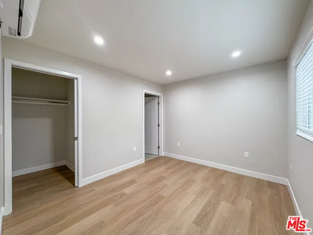 an empty room with wooden floor and closet