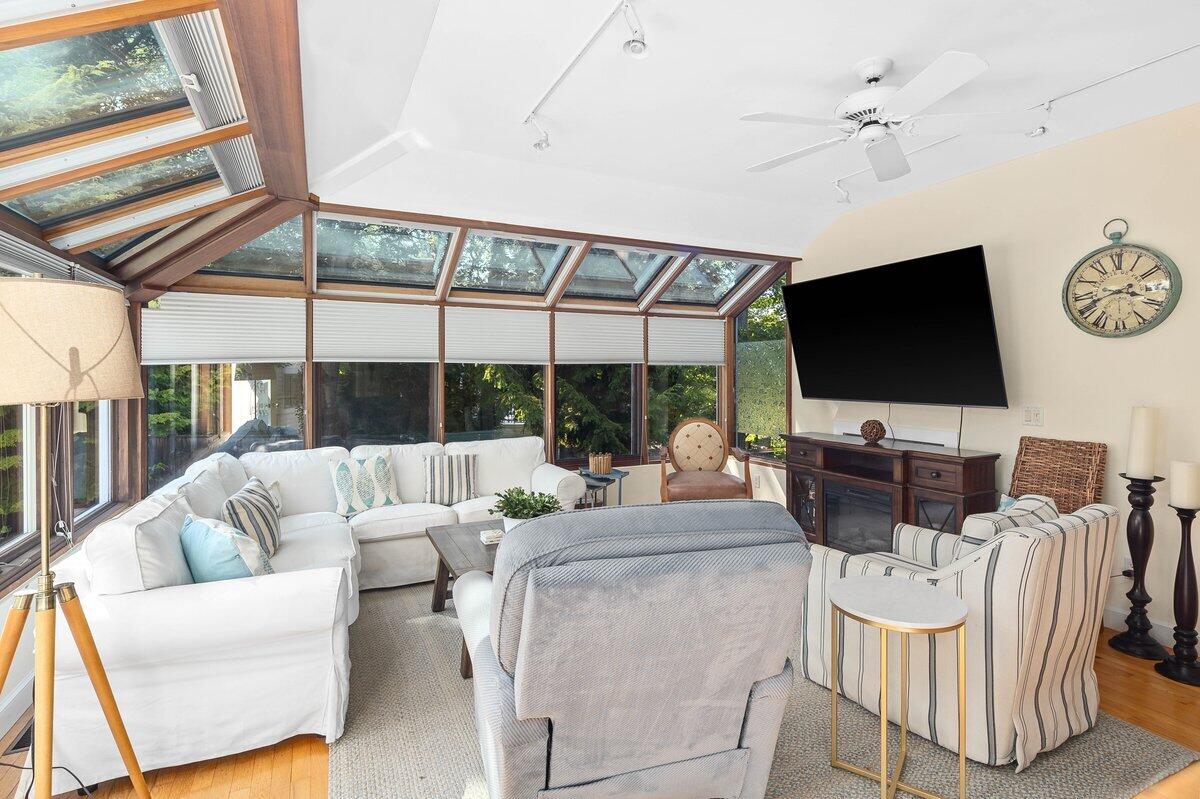 77 Tide Run Mashpee, MA 02649 - Photo 15 of 44 a living room with furniture a flat screen tv and a floor to ceiling window