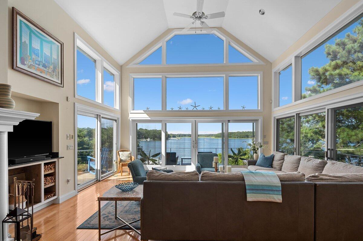 77 Tide Run Mashpee, MA 02649 - Photo 6 of 44 a living room with fireplace furniture large windows and a flat screen tv