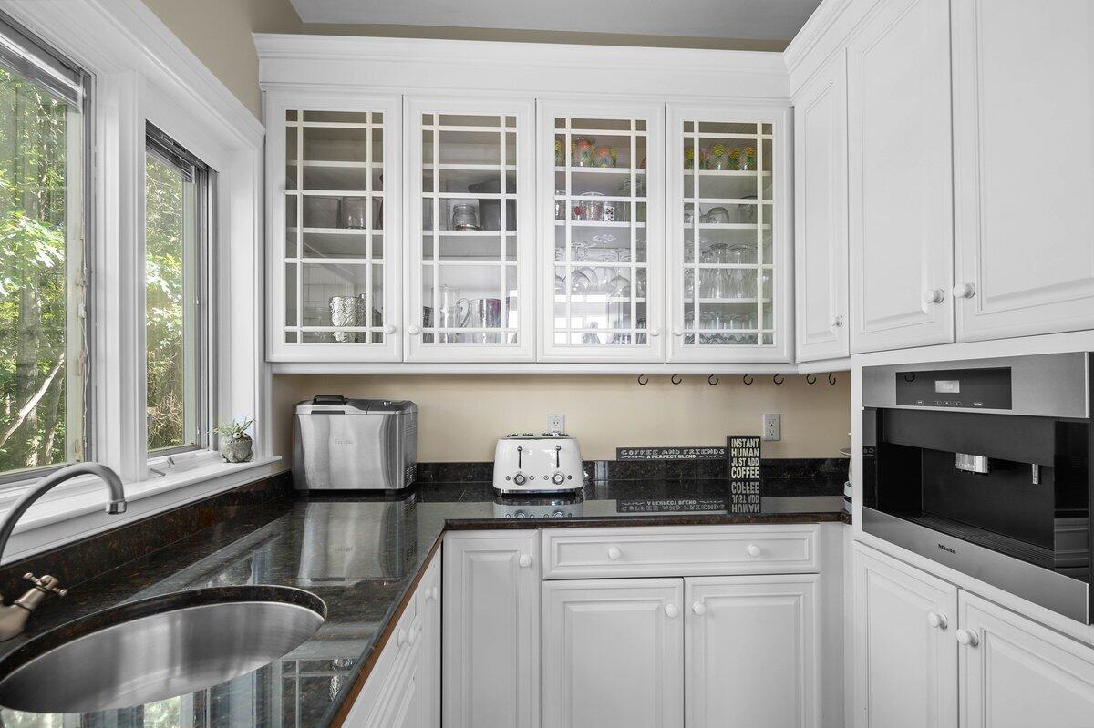 77 Tide Run Mashpee, MA 02649 - Photo 9 of 44 a kitchen with granite countertop a sink a stove and cabinets