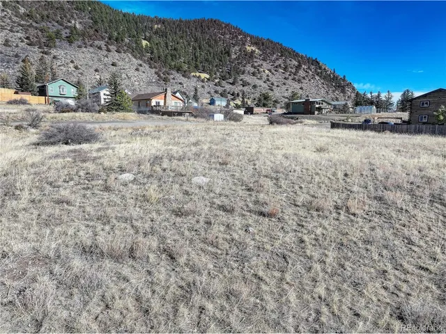 a view of a dry yard with wooden fence