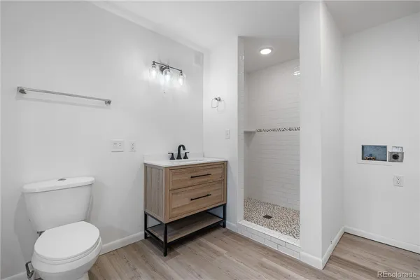 a bathroom with a toilet a sink a mirror and shower