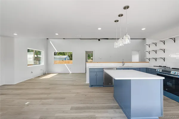 a kitchen with stainless steel appliances granite countertop a sink a stove top oven a counter space and cabinets