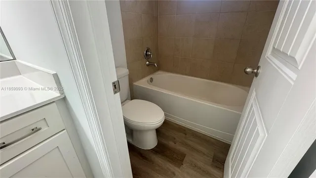 an empty room with wooden floor cabinet and door
