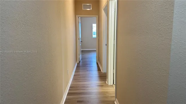 a view of hallway with wooden floor