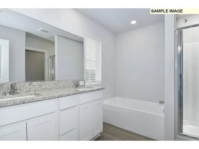 a bathroom with a granite countertop sink a mirror and a bathtub